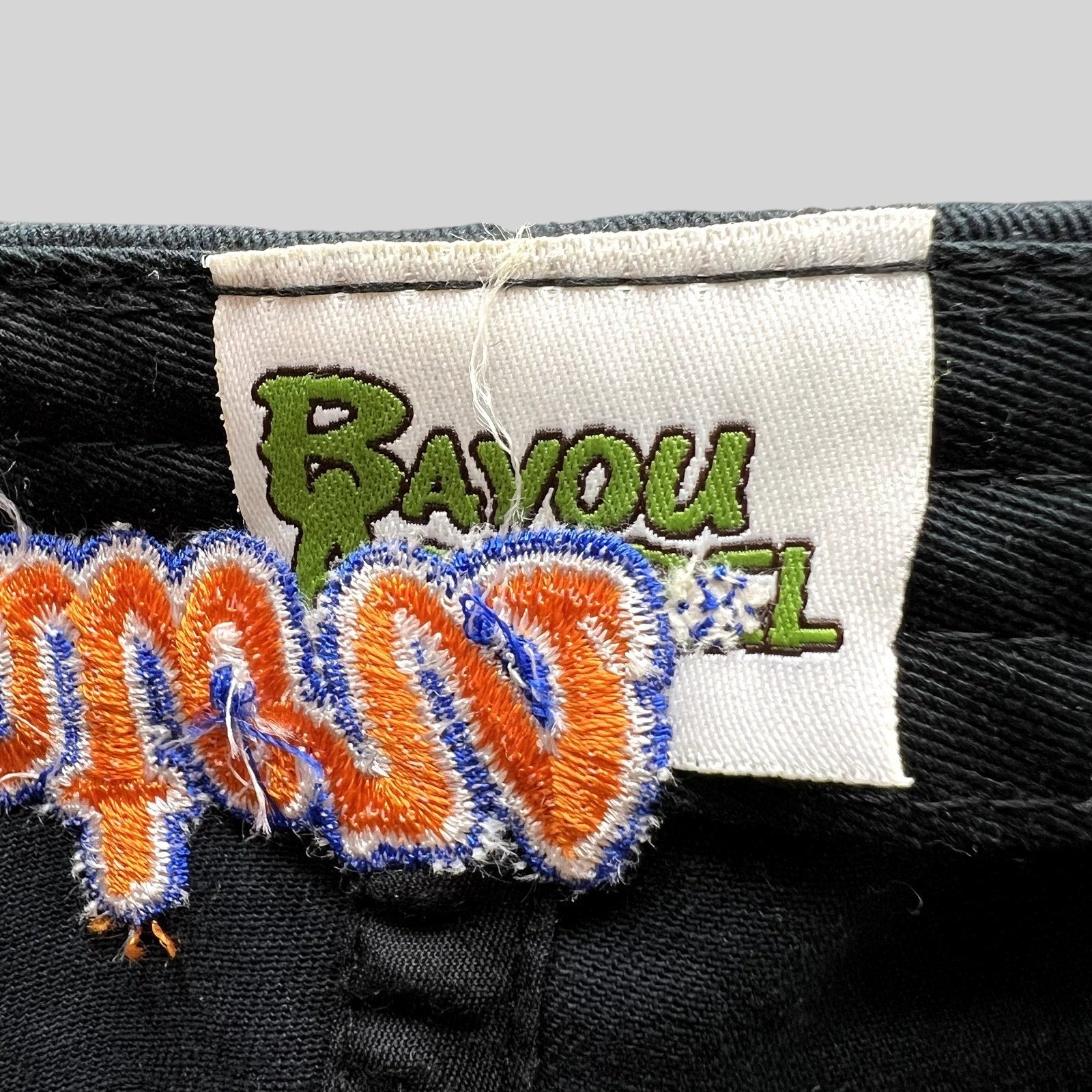 Raree Finds Bayou Apparel brand label stitched inside a black cotton strapback college football hat