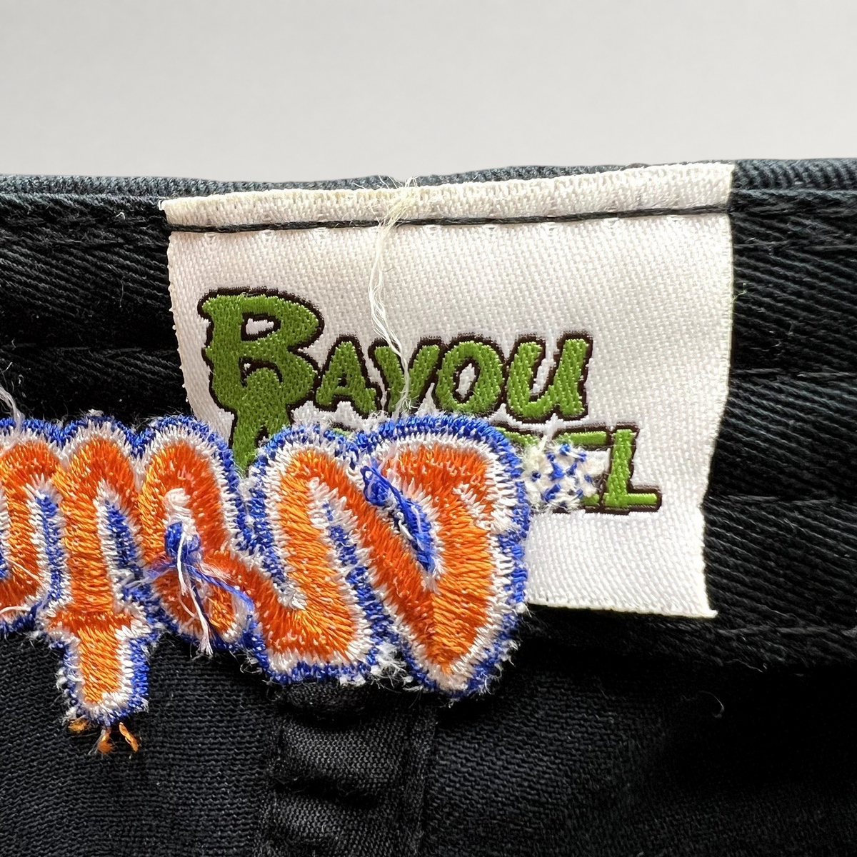 Raree Finds Bayou Apparel brand label stitched inside a black cotton strapback college football hat