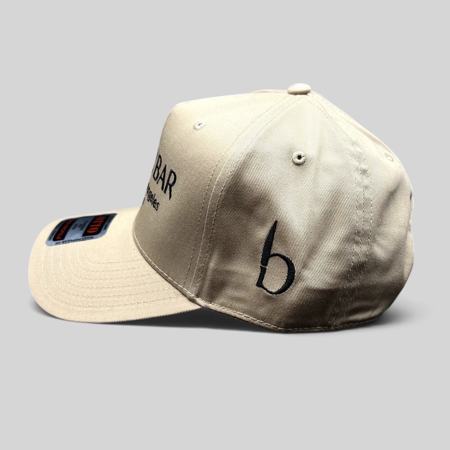 Raree Finds beige BUTCHR BAR snapback hat with black embroidered logo and side detail on a curved brim OTTO blank