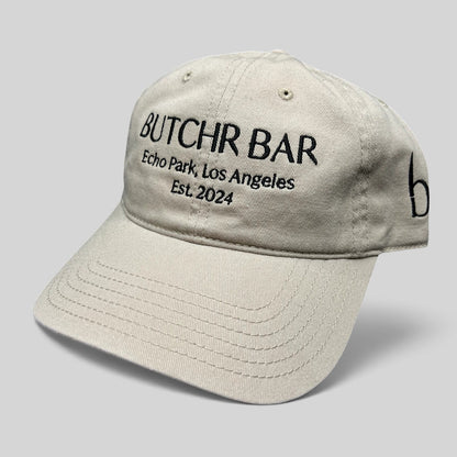 Raree Finds beige cotton twill dad hat with black Butchr Bar Echo Park Los Angeles embroidery and strapback closure.