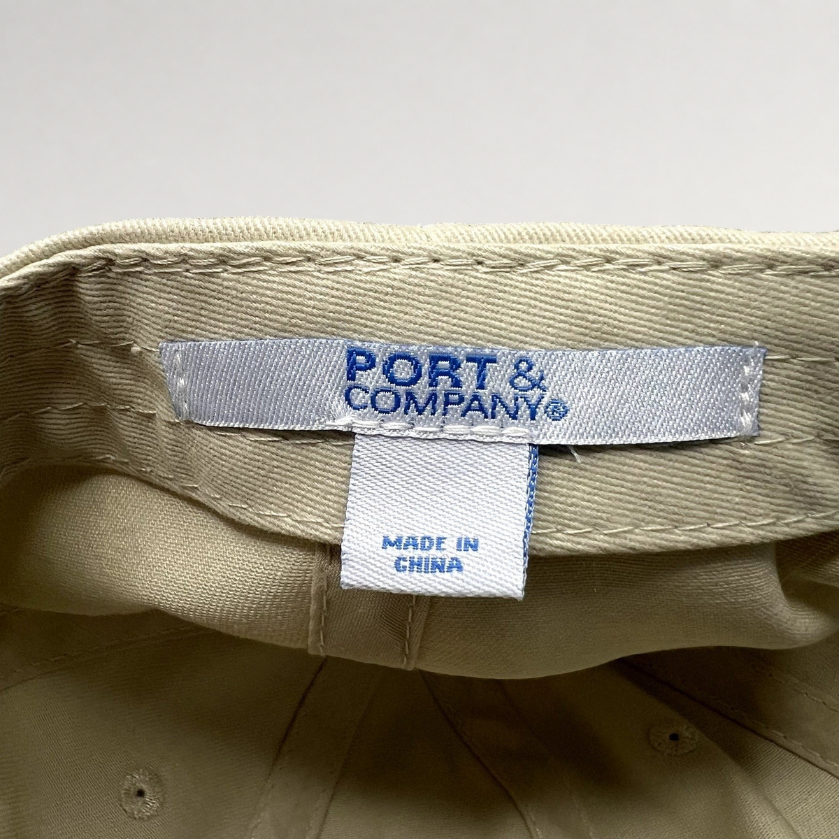 Raree Finds beige cotton strapback hat interior showing Port & Company brand label and Made in China tag