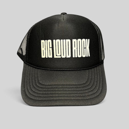 Raree Finds black Otto trucker hat with white BIG LOUD ROCK graphic, foam front, and breathable mesh back panels.