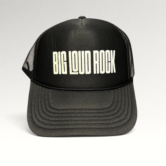Raree Finds black Otto trucker hat with white BIG LOUD ROCK graphic, foam front, and breathable mesh back panels.