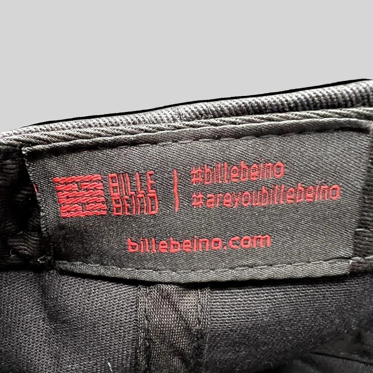 Raree Finds Bille Beino black strapback hat interior fabric label with red embroidered brand logo and website text