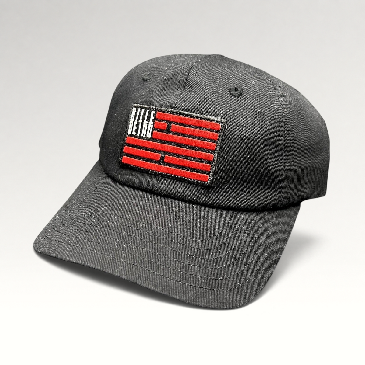 Raree Finds BilleBeino black strapback hat with a red embroidered geometric flag logo on the front crown
