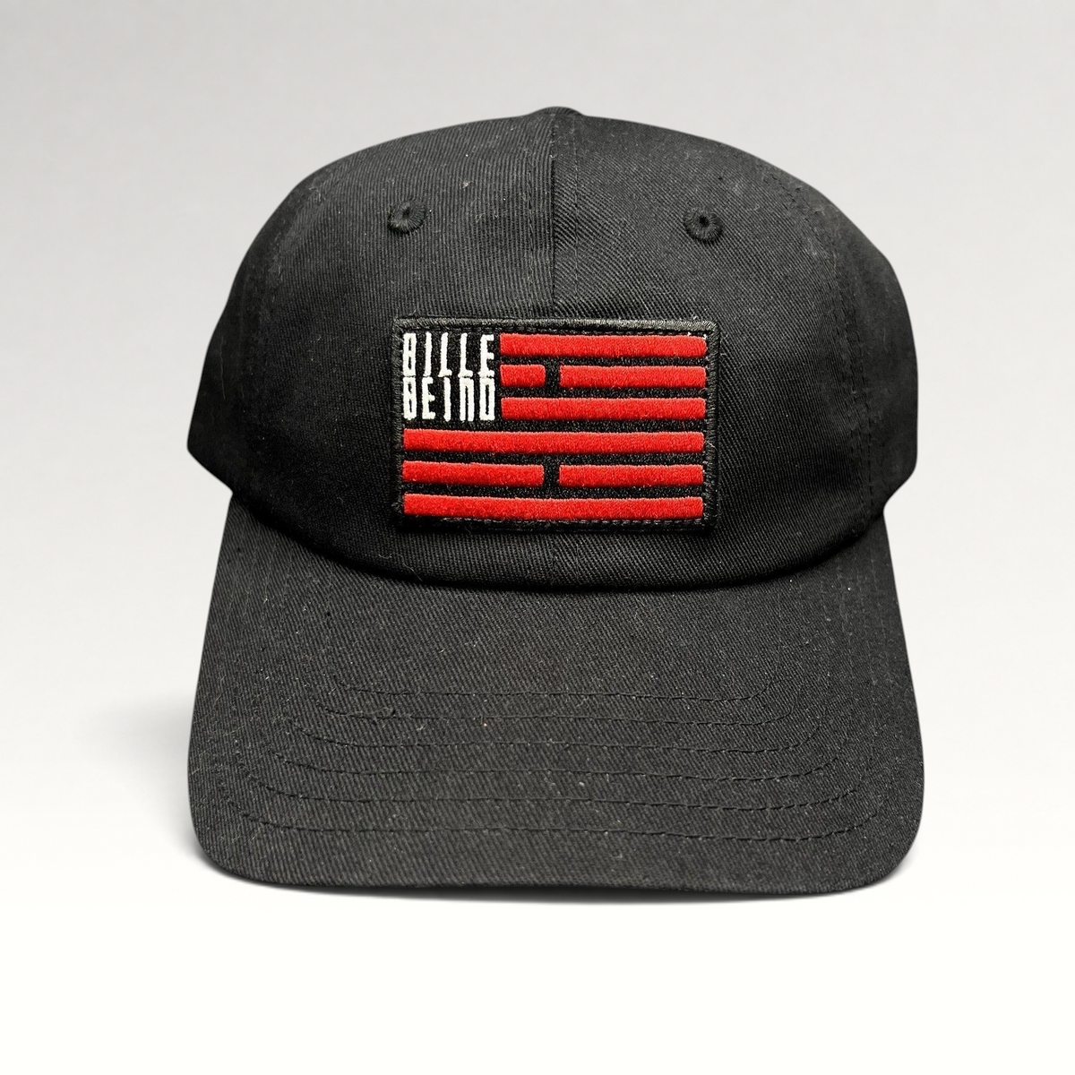 Raree Finds BilleBeino black strapback hat with a red embroidered flag logo patch and curved brim