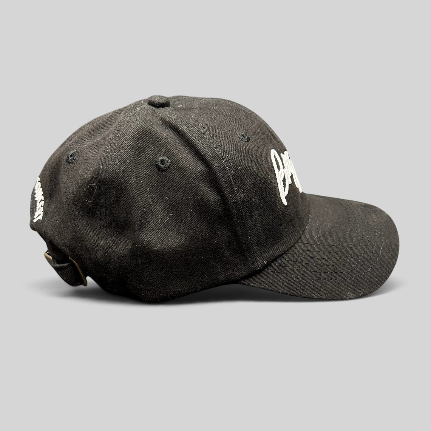 Raree Finds black Billy Joel In Concert strapback hat with white script embroidery and brass buckle side view