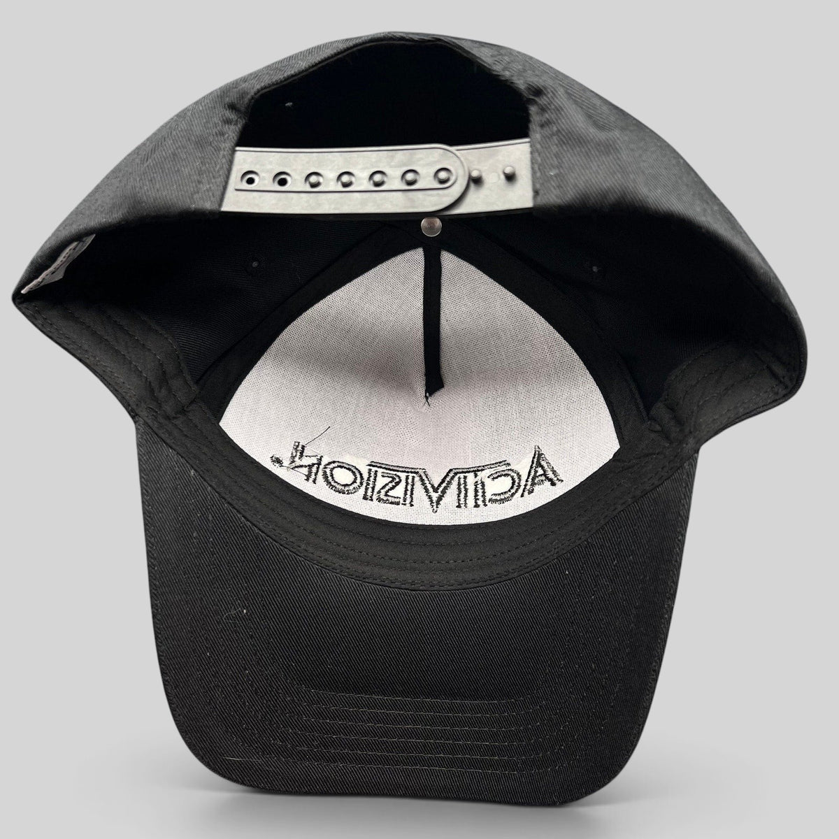Raree Finds black Activision snapback hat showing the interior adjustable plastic strap and embroidered logo detail.