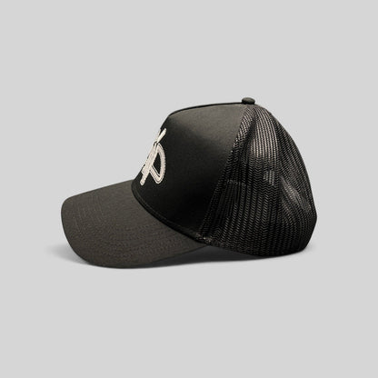 Raree Finds black mesh trucker hat with embroidered white AMP logo, structured crown, and adjustable snapback.