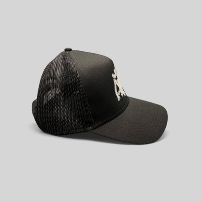 Raree Finds black mesh trucker hat with embroidered white AMP logo, featuring a structured crown and snapback closure.