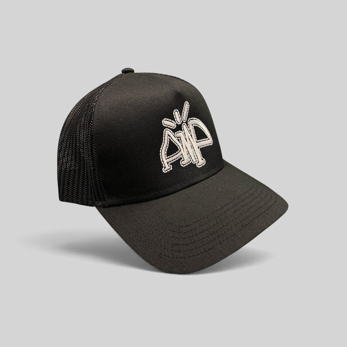 Raree Finds black trucker hat with breathable mesh back and white embroidered AMP logo on the structured front panel.