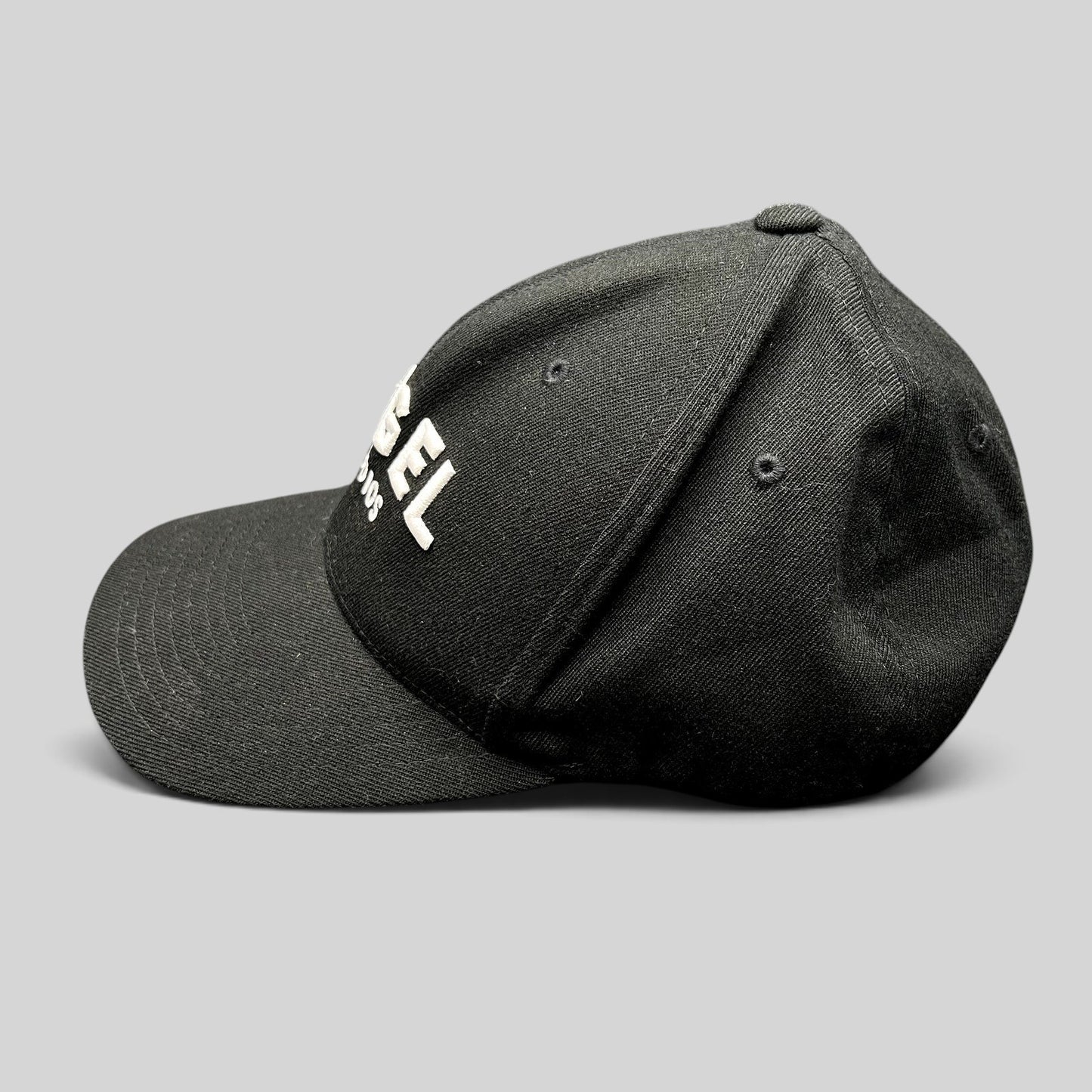 Raree Finds black Flexfit cap with white embroidered Angel Studios logo and curved brim, side profile view.