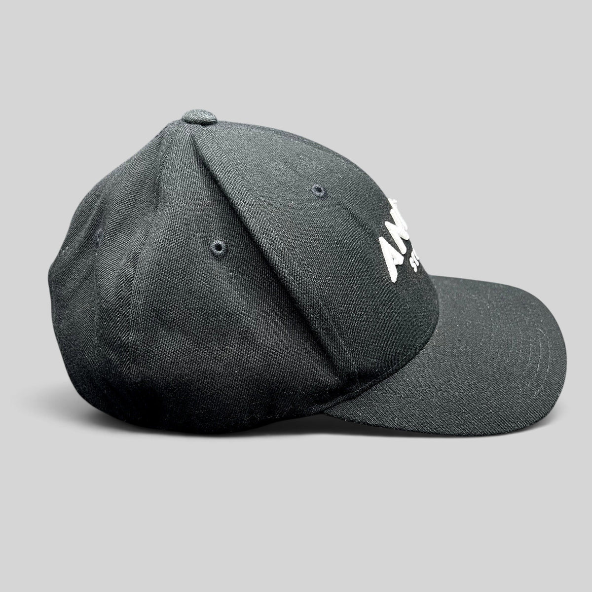Raree Finds black Flexfit hat with white embroidered Angel Studios logo and curved brim, side profile view.
