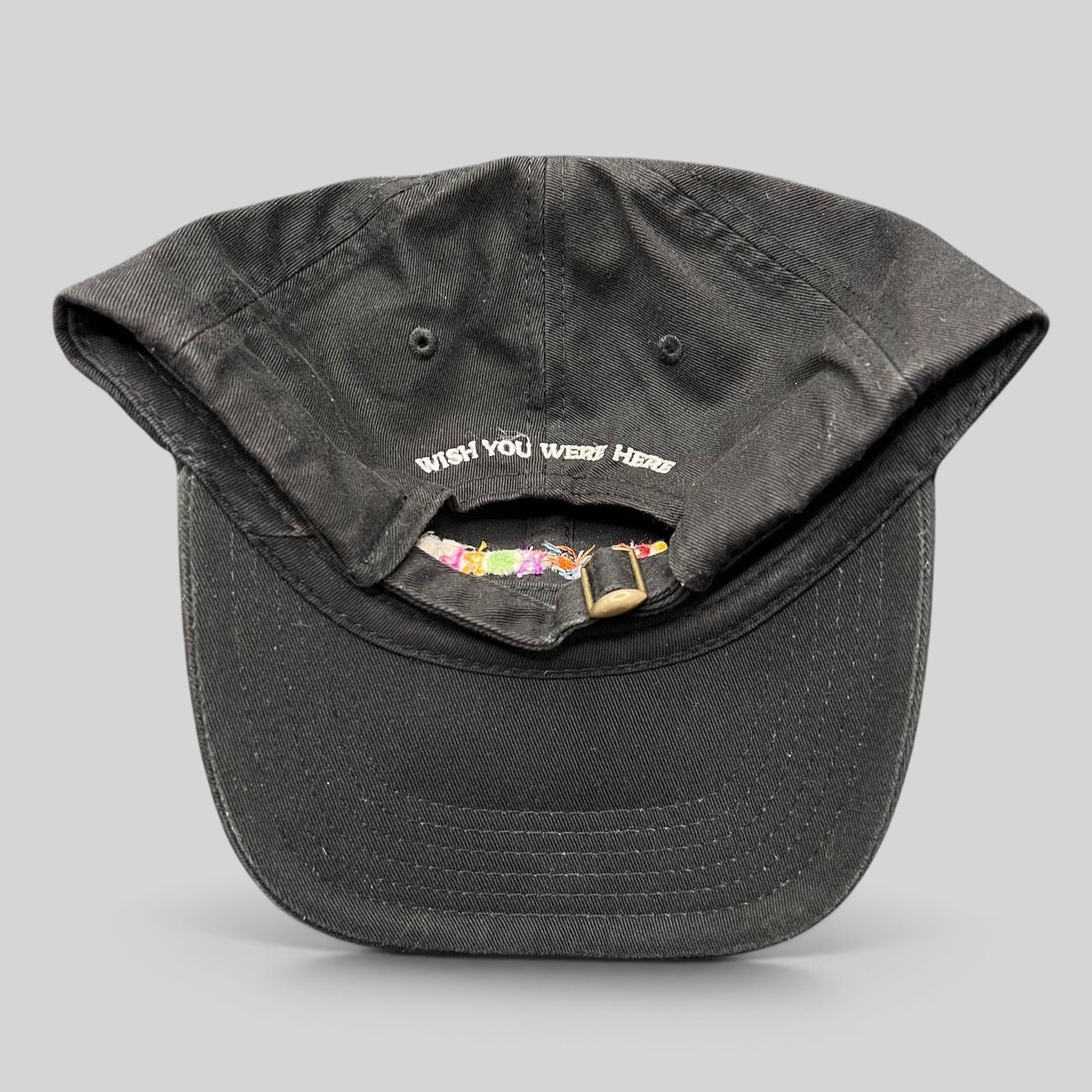 Raree Finds black cotton strapback hat with Wish You Were Here embroidery on the back and metal slider closure