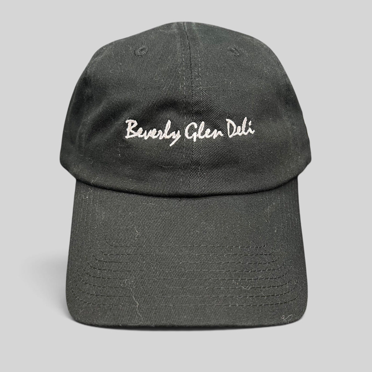 Raree Finds black cotton strapback hat with white Beverly Glen Deli cursive script embroidery on the front