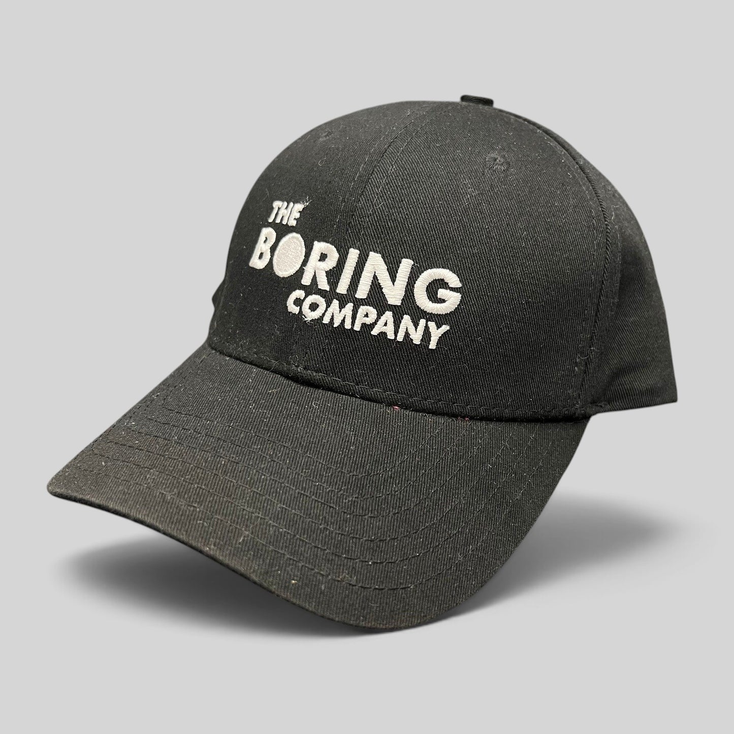 Raree Finds black The Boring Company strapback hat with white embroidered logo on the front and curved brim