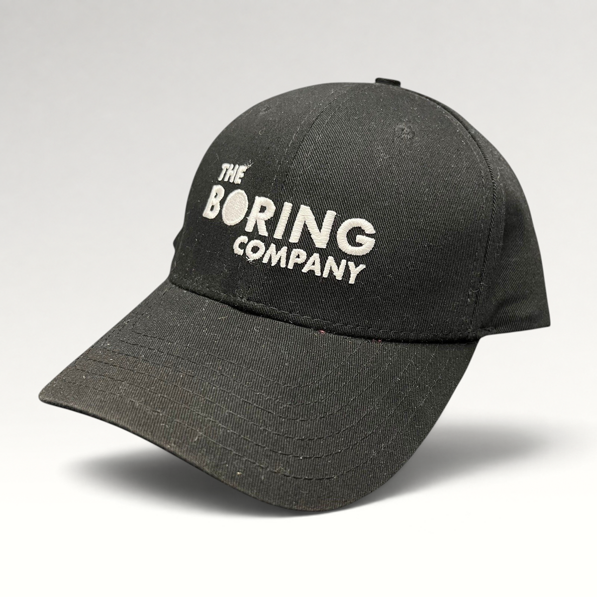 Raree Finds black The Boring Company strapback hat with white embroidered logo on the front and curved brim