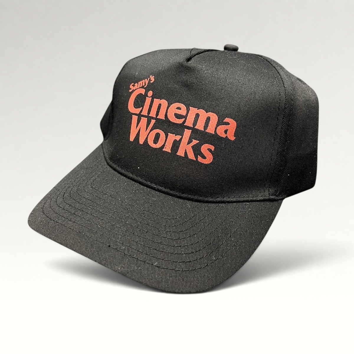 Raree Finds black cotton twill strapback hat with red Samy's CinemaWorks promotional embroidery on the front crown.