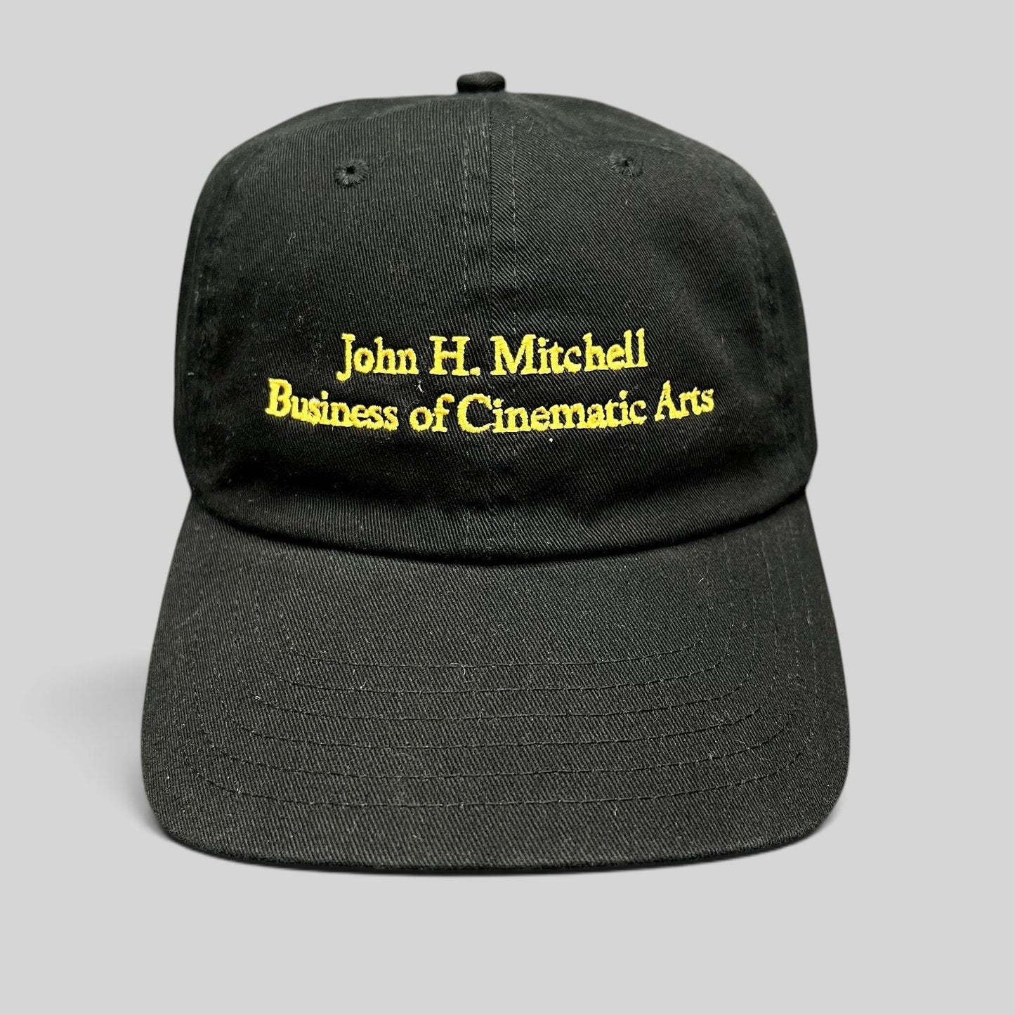 Raree Finds black cotton strapback hat with gold embroidered John H. Mitchell Business of Cinematic Arts lettering.