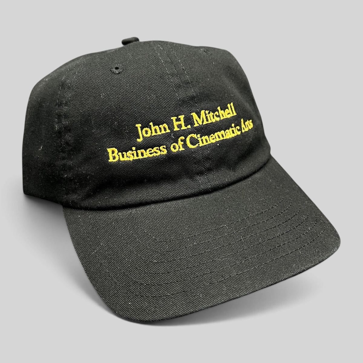 Raree Finds black cotton strapback hat with gold embroidered John H. Mitchell Business of Cinematic Arts lettering