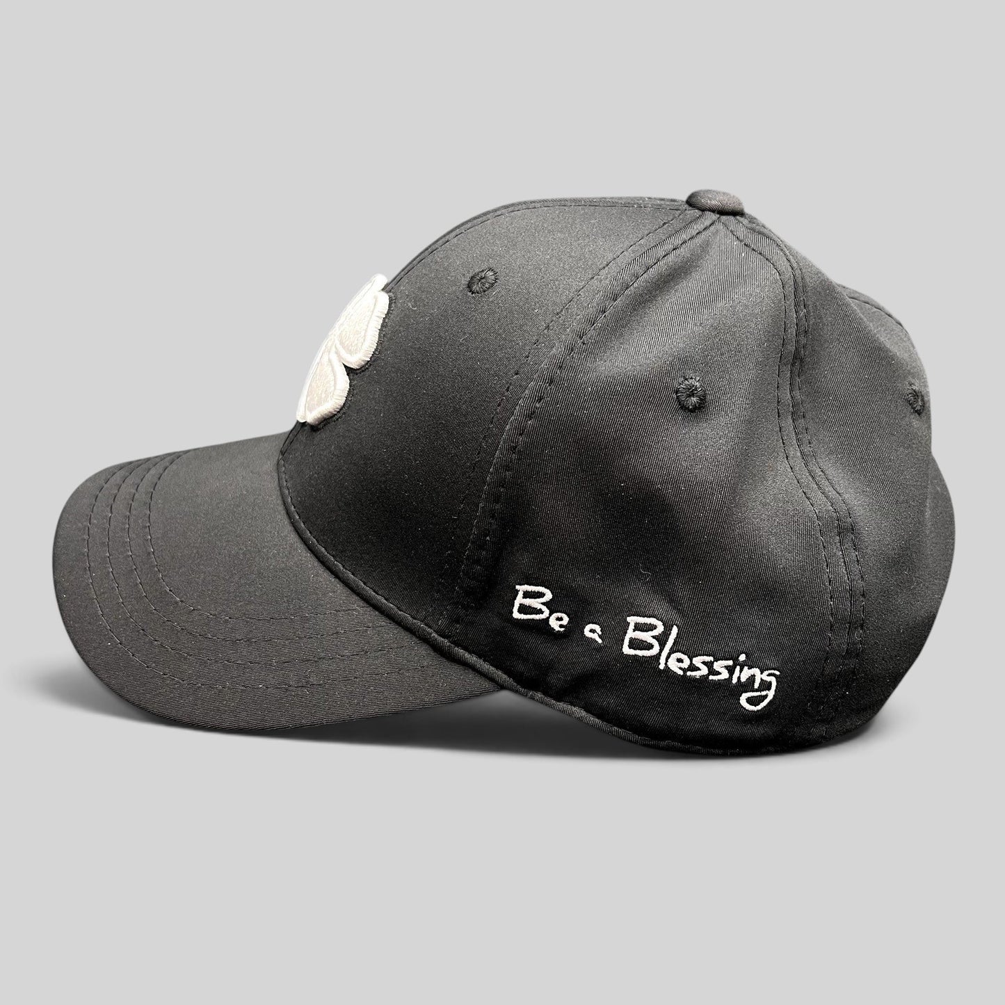 Raree Finds black snapback golf hat featuring a white clover logo and Be a Blessing embroidery on the side