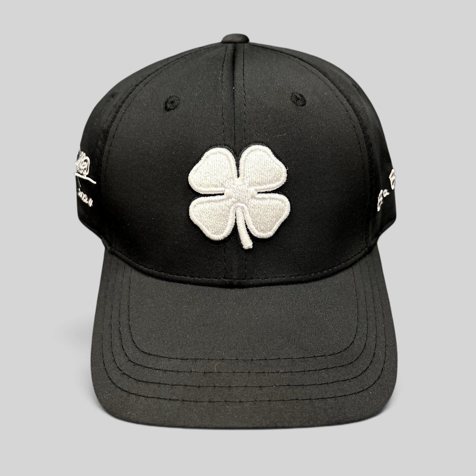 Raree Finds black snapback golf hat featuring a large white embroidered clover logo and Blessed 2024 side branding.