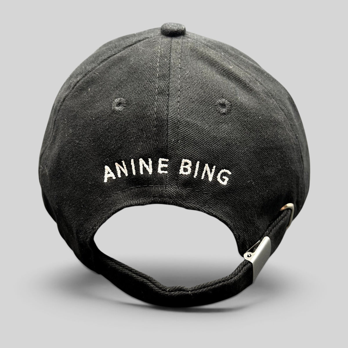 Raree Finds black cotton dad cap with white ANINE BING logo embroidery on the back and adjustable metal buckle strap