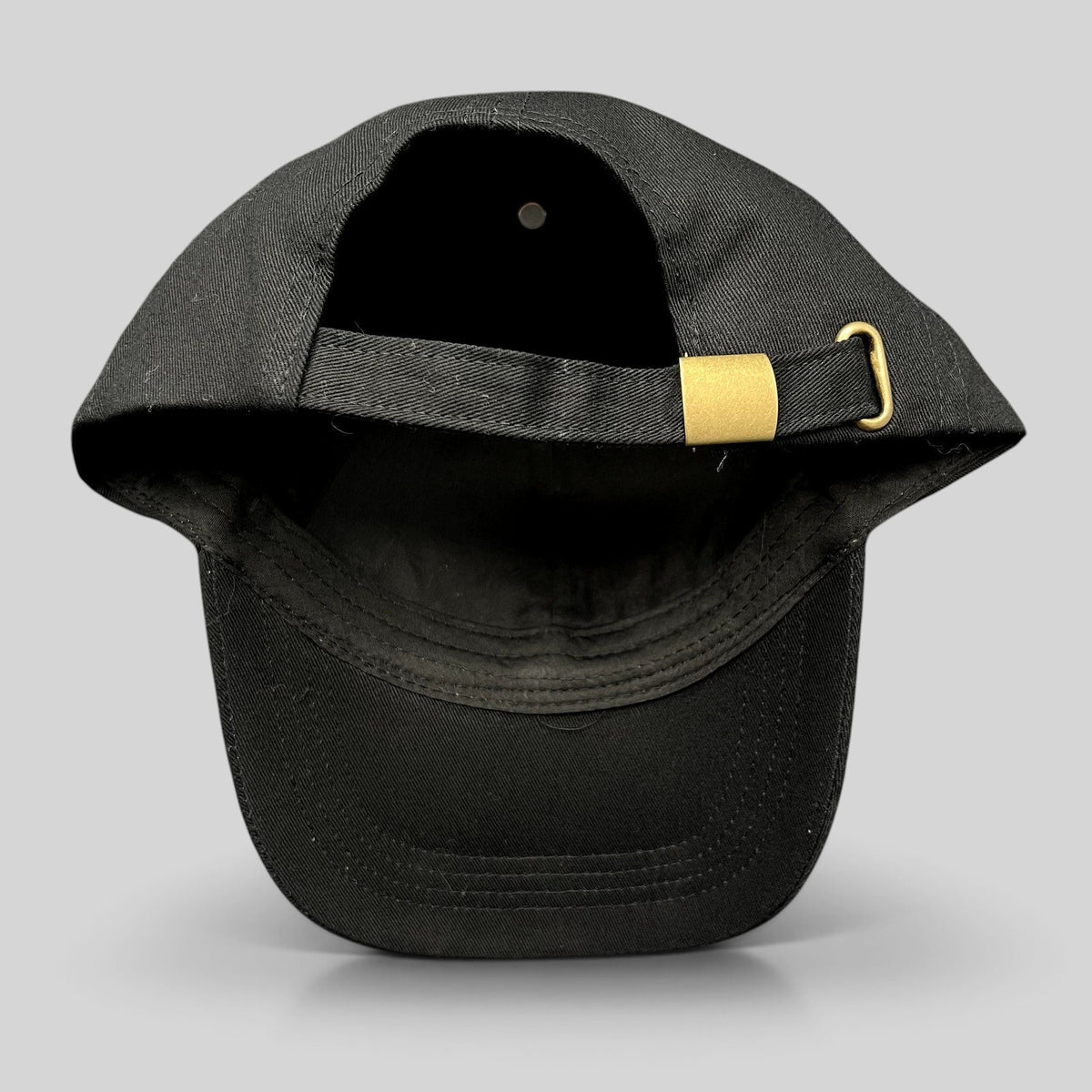Raree Finds black cotton strapback hat with gold metal buckle closure, rear view showing adjustable strap