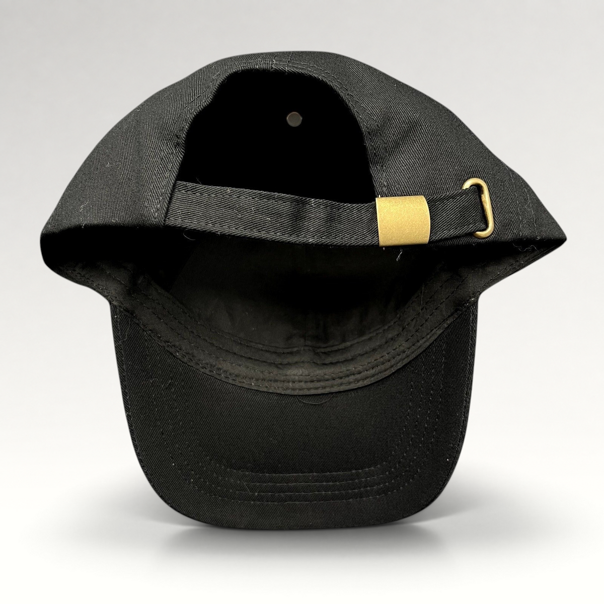 Raree Finds black cotton strapback hat with gold metal buckle closure, rear view showing adjustable strap