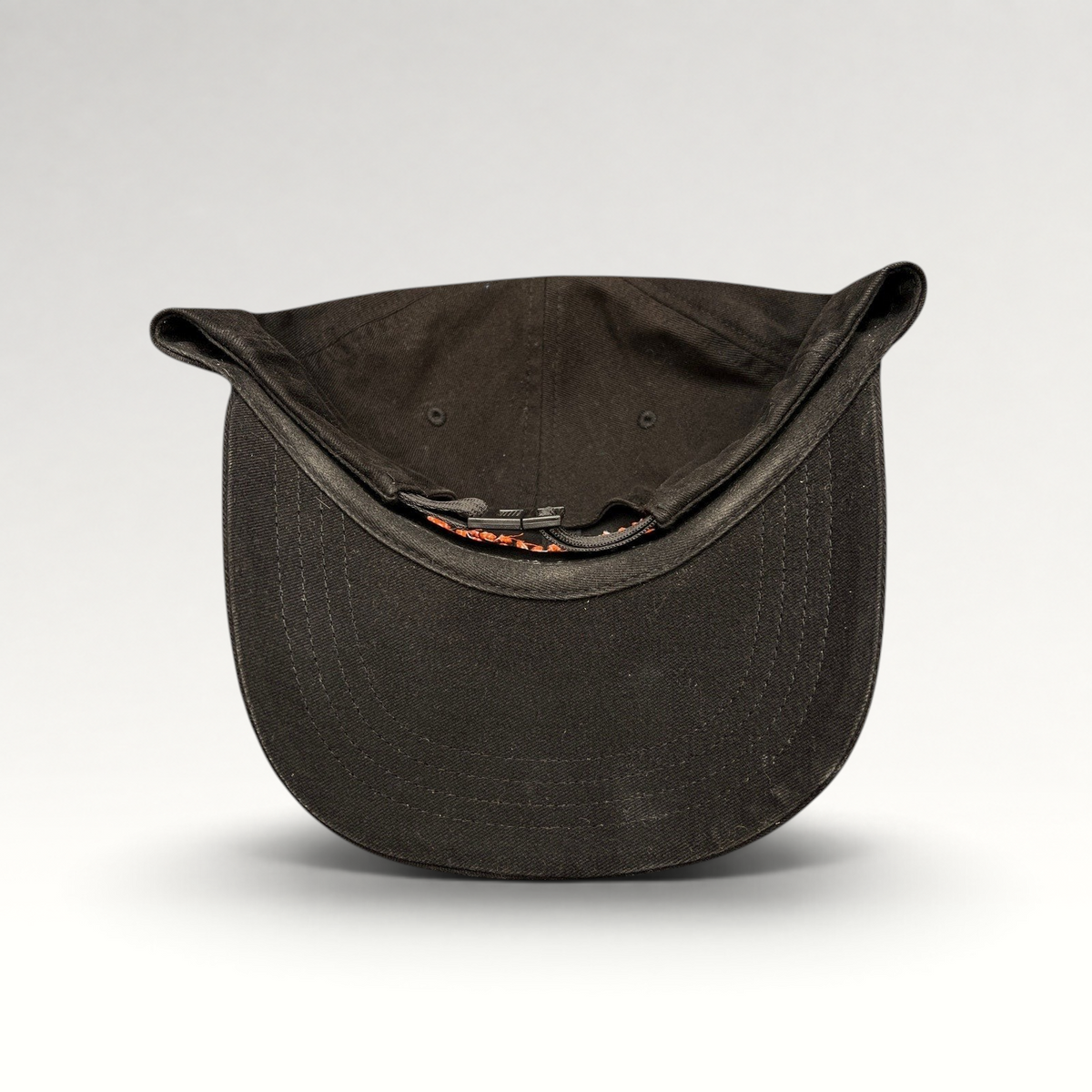 Raree Finds black cotton strapback hat with orange embroidered lettering and metal buckle closure