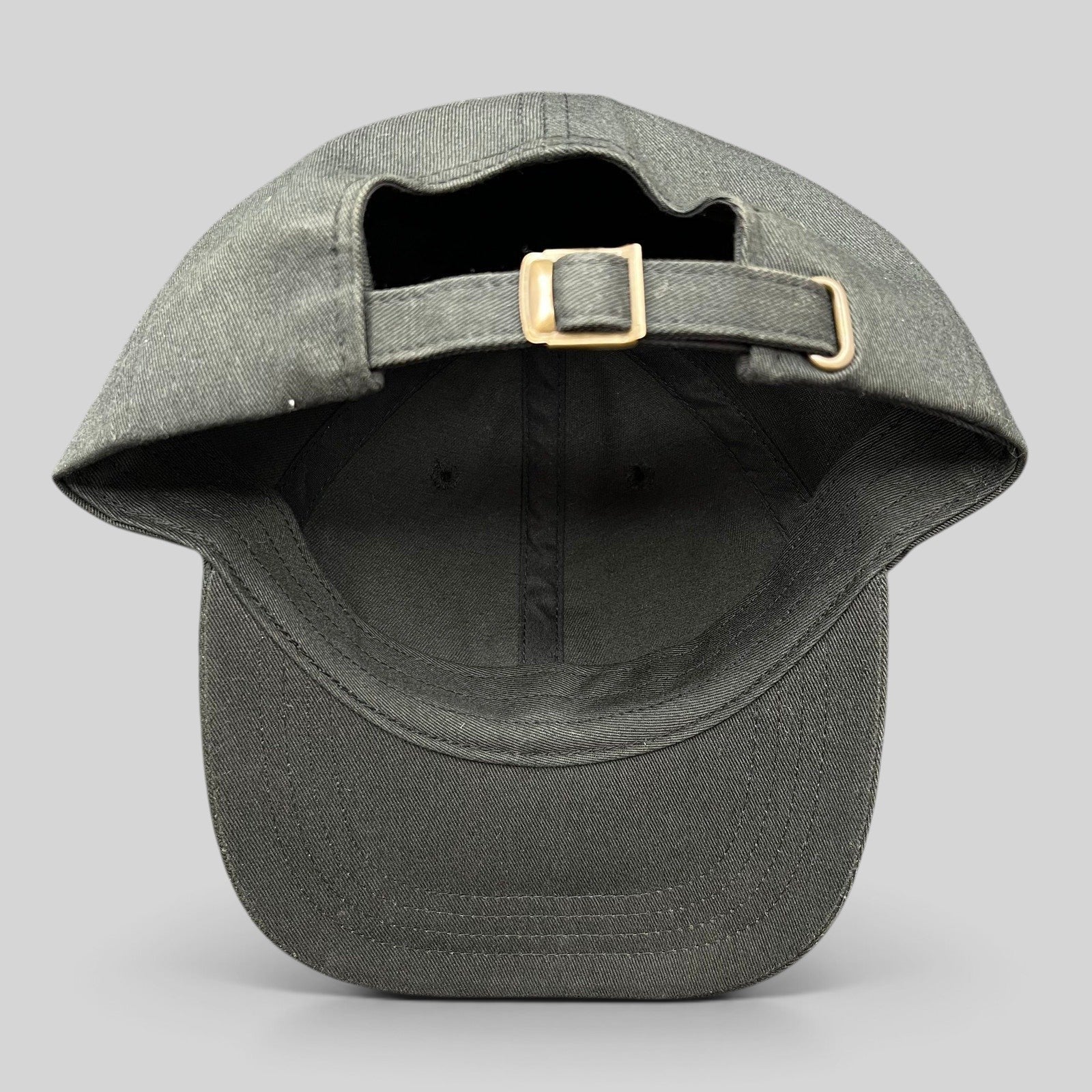 Raree Finds black cotton strapback hat with adjustable metal buckle closure, showing the back view.