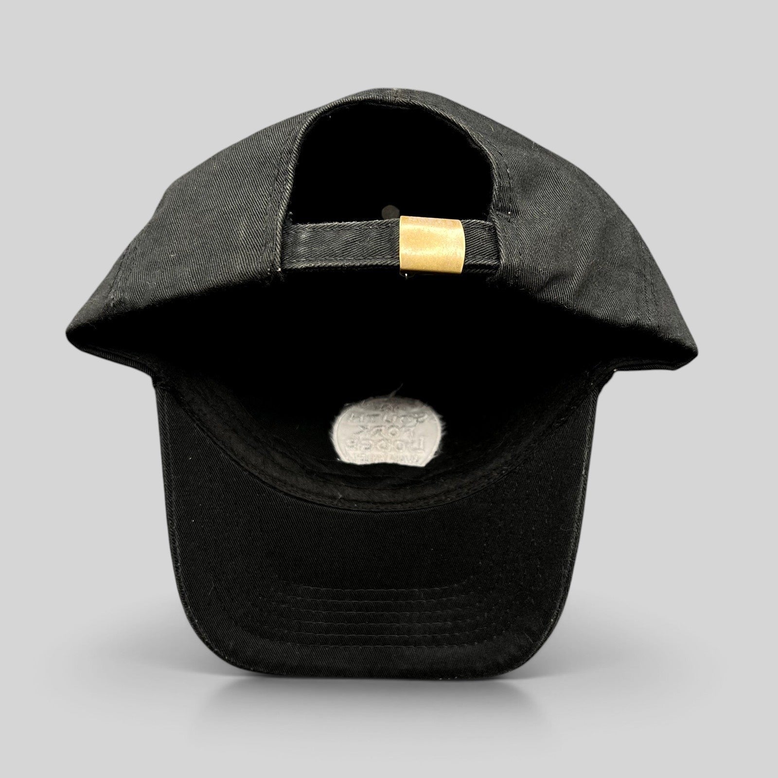 Raree Finds black cotton strapback hat with adjustable brass buckle, showing the back view of the cap.