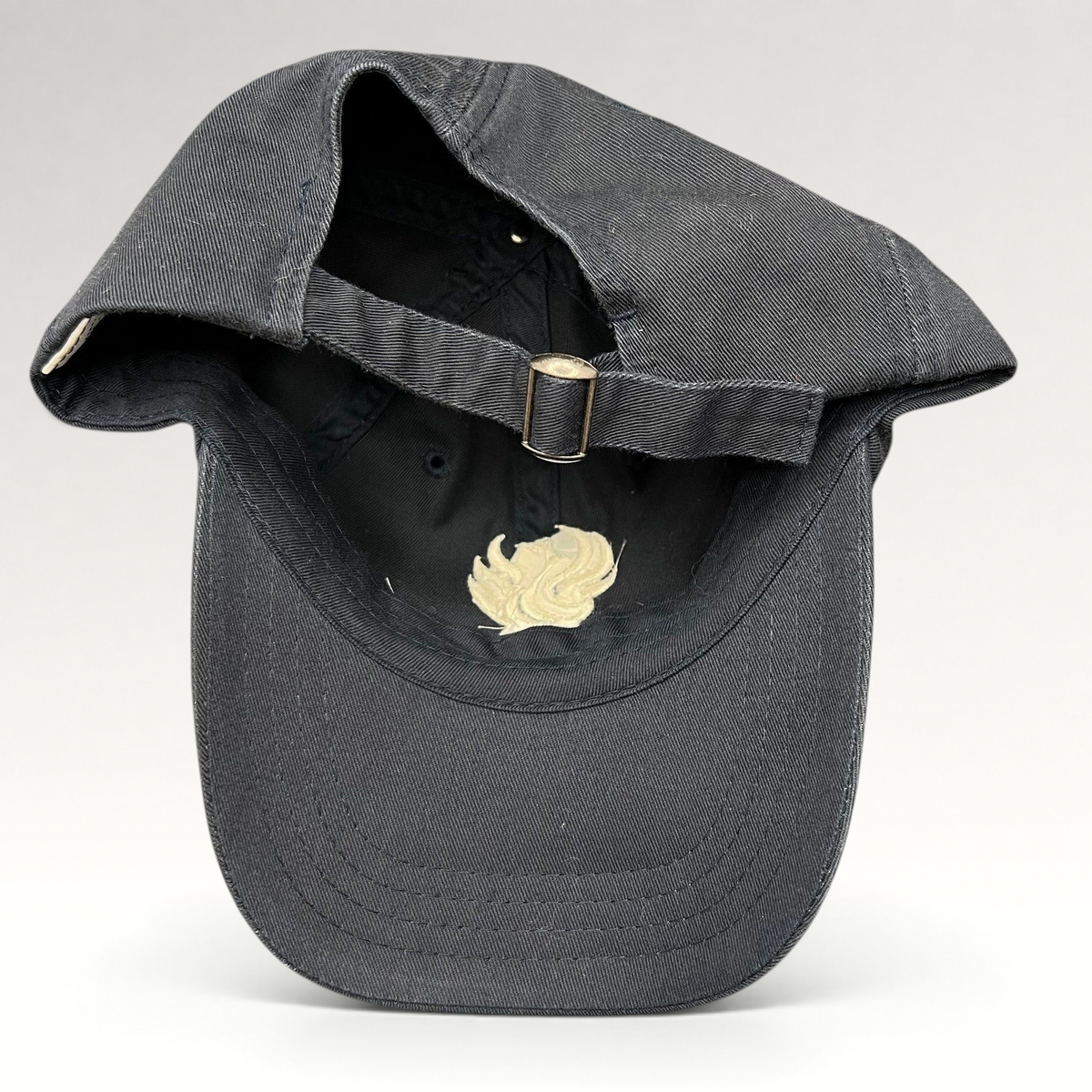 Raree Finds black cotton strapback hat from The Phoenician Scottsdale showing the adjustable metal buckle closure