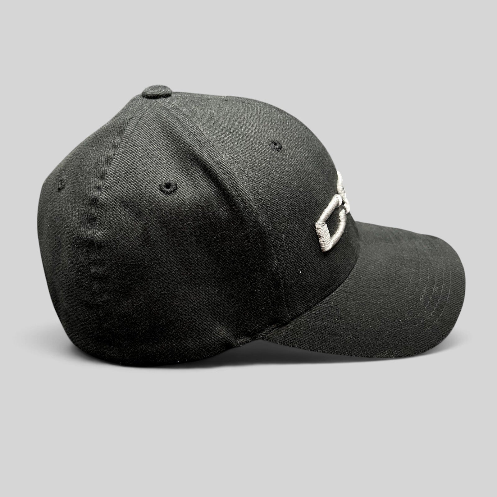 Raree Finds black Yupoong Flexfit cap with raised white CSI embroidery, side profile view.
