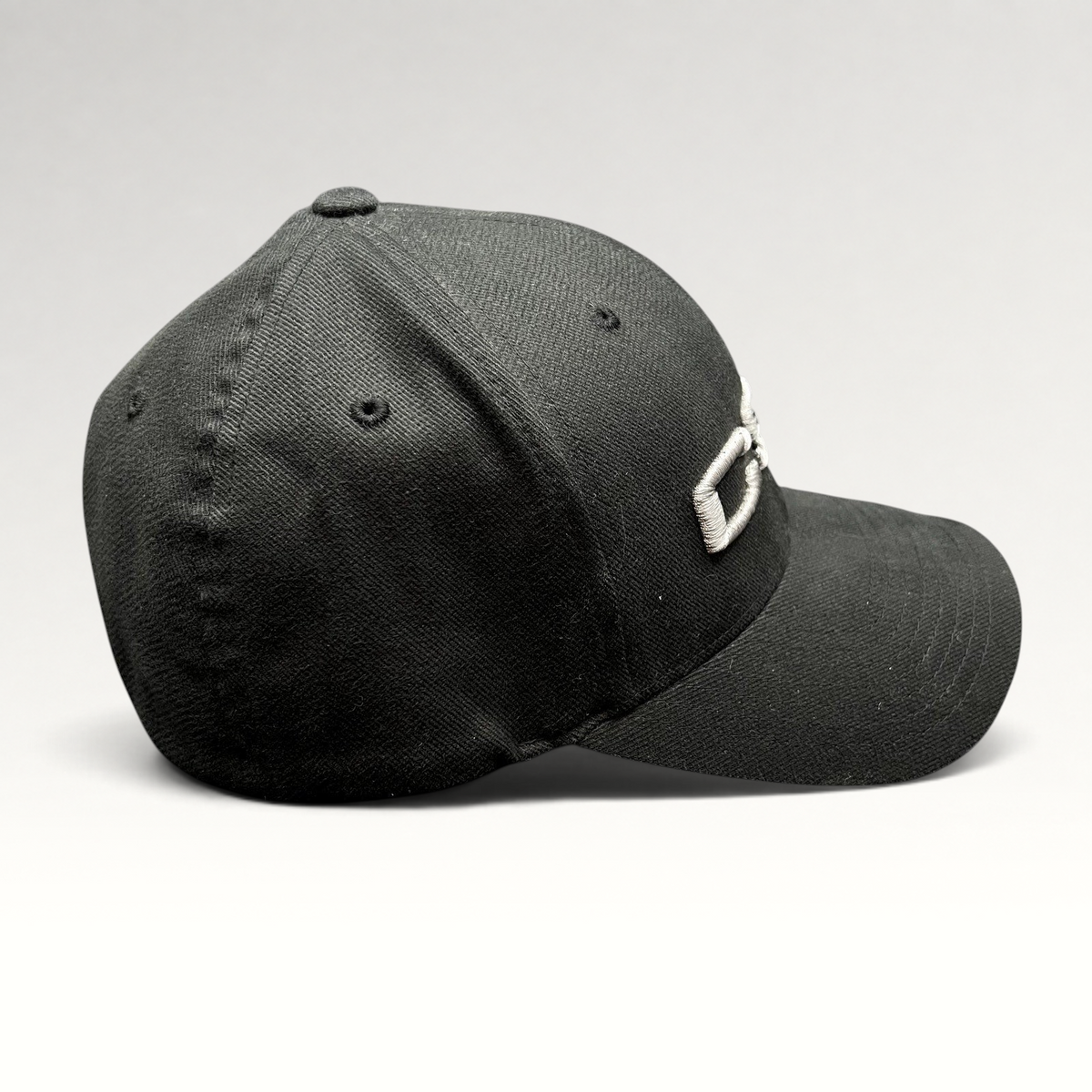 Raree Finds black Yupoong Flexfit cap with raised gray CSI embroidery on the side, made from cotton and spandex.