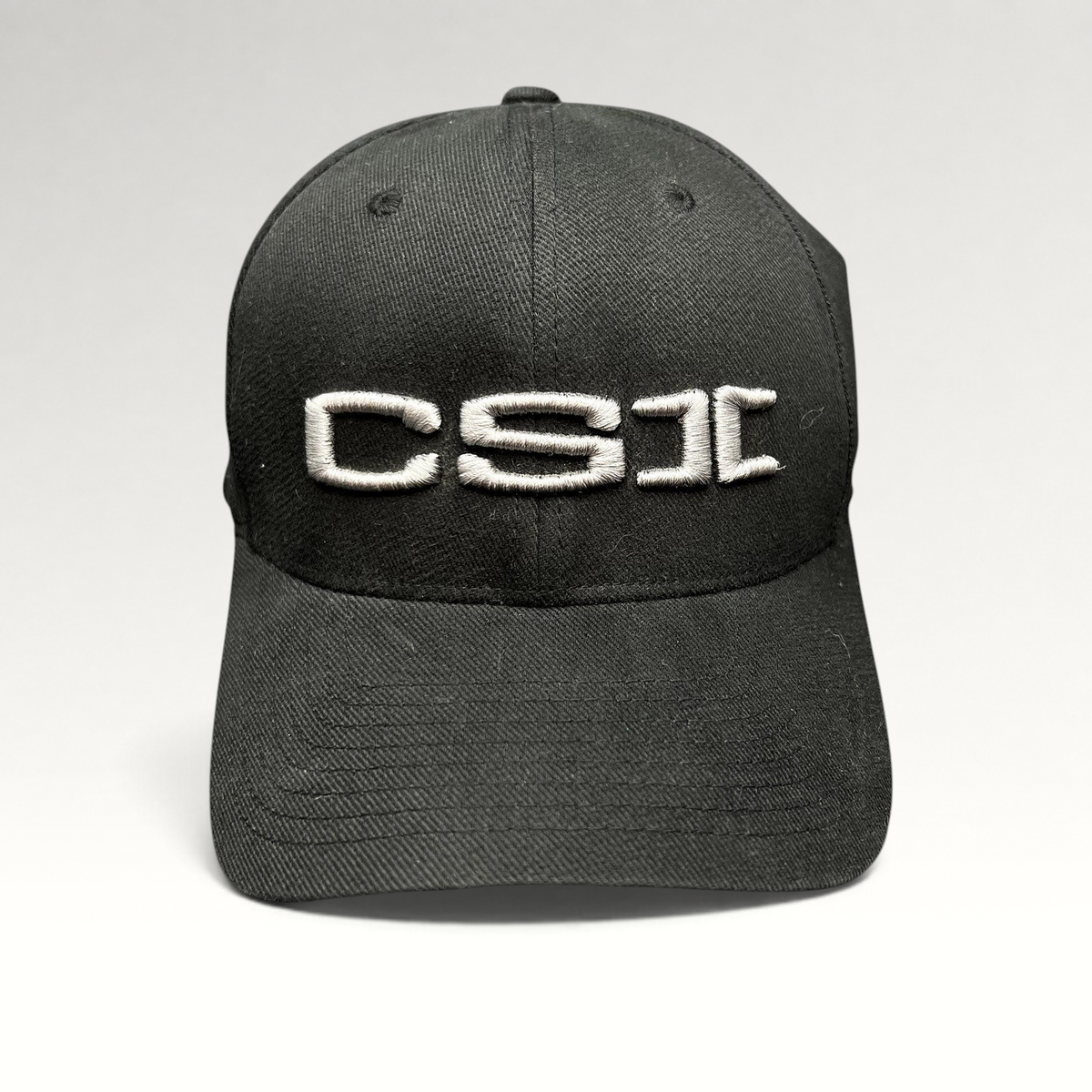 Raree Finds black Yupoong Flexfit cap with raised gray CSI embroidery on the front, production staff style.