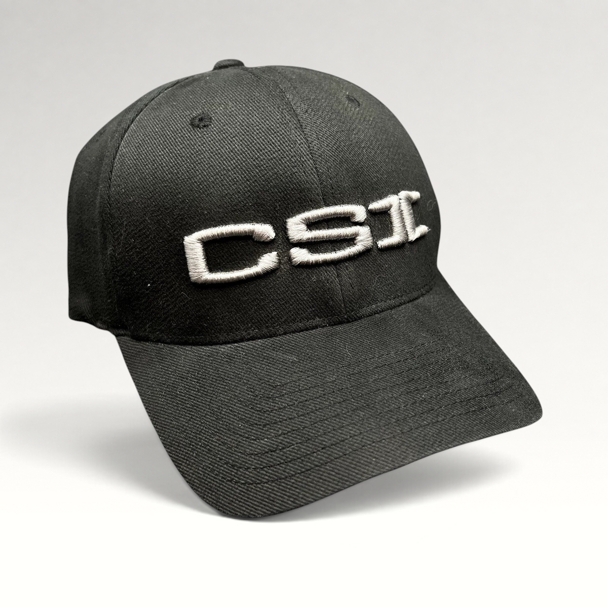 Raree Finds black Yupoong Flexfit cap with raised gray CSI embroidery on the front, made from cotton and spandex.