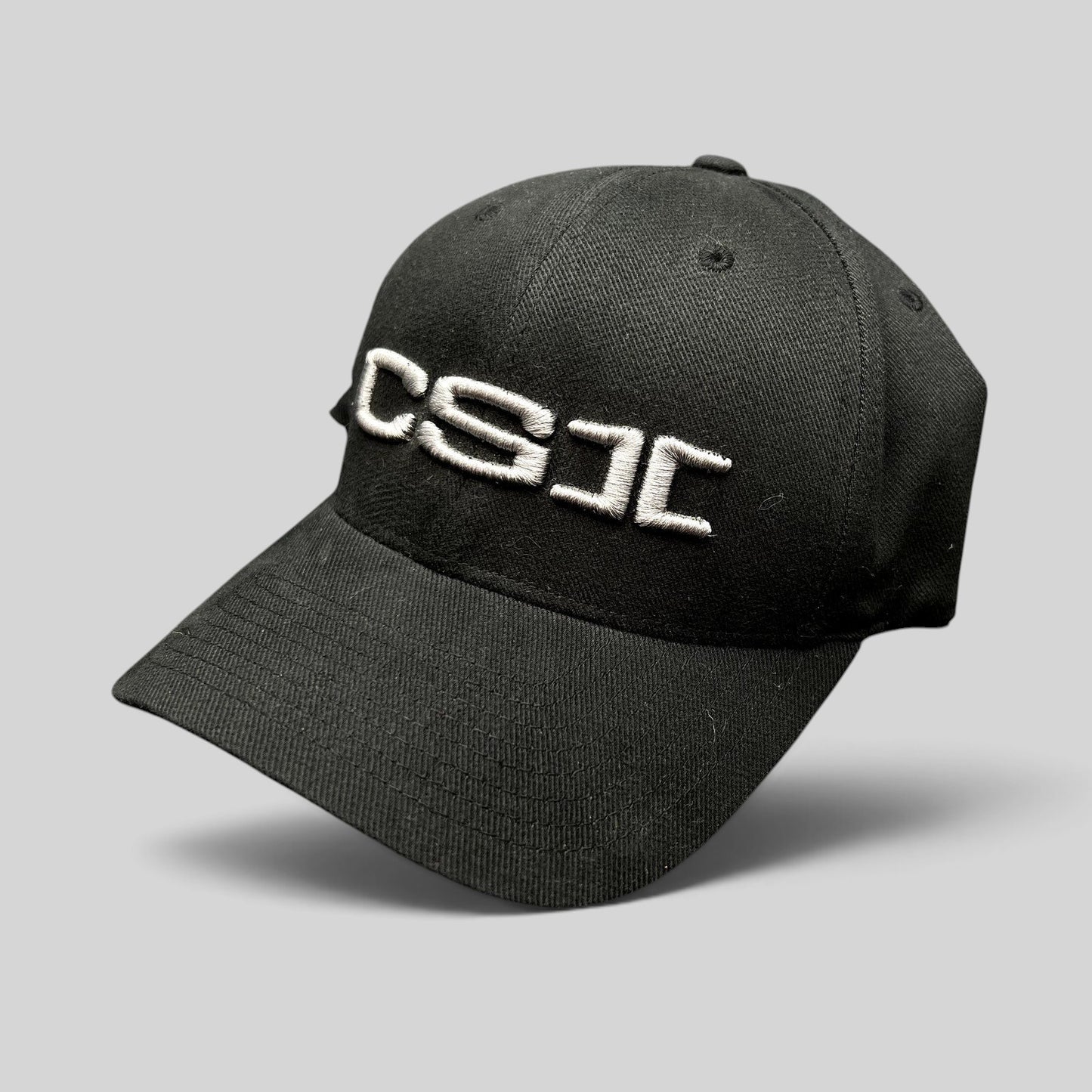 Raree Finds black Yupoong Flexfit cap with raised white CSI embroidery on the front, production staff style.