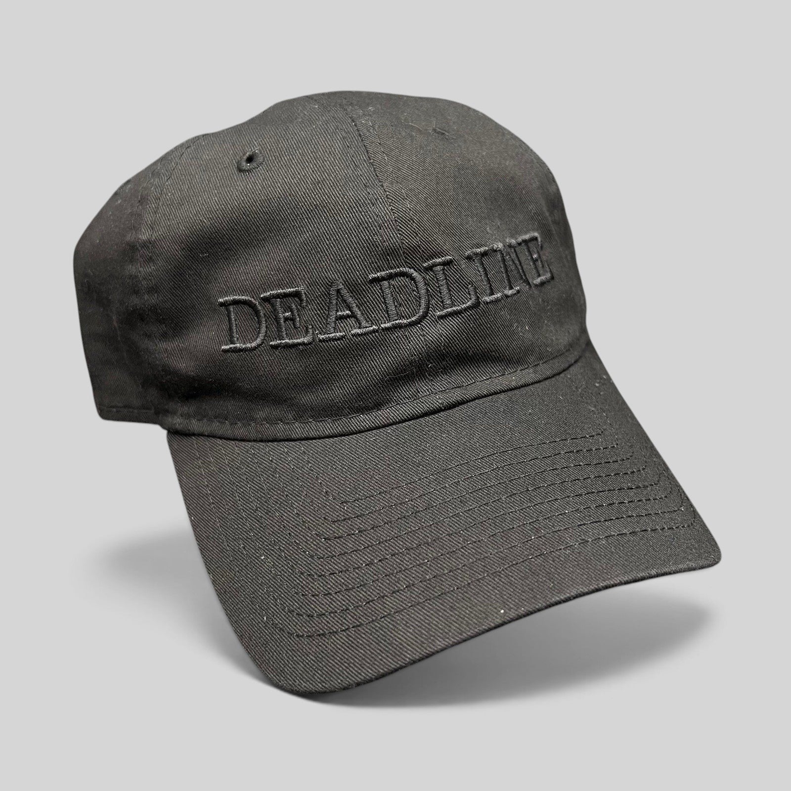 Raree Finds black New Era 9TWENTY strapback hat with tonal DEADLINE embroidery on the front and a curved brim.