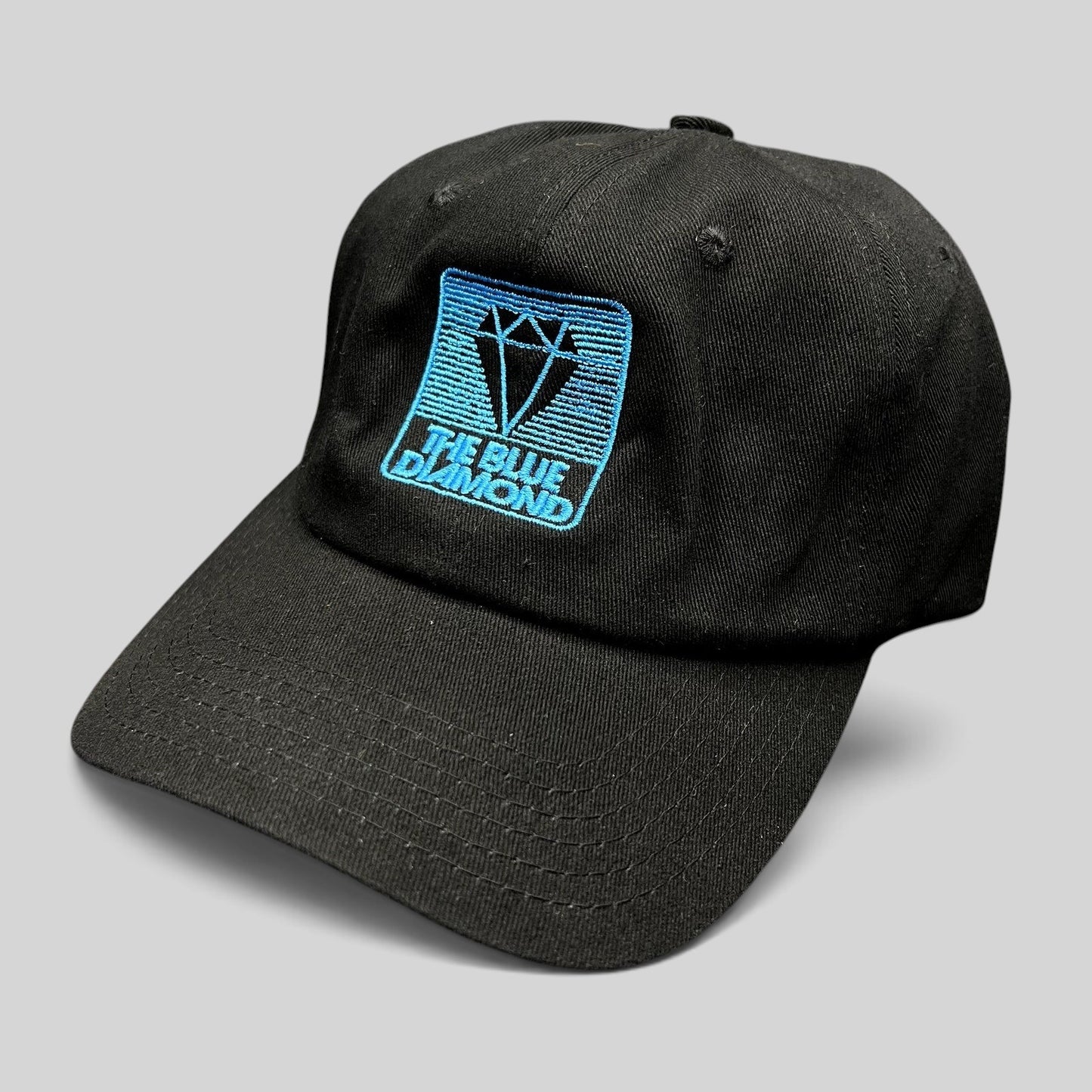 Raree Finds black cotton strapback hat with a blue embroidered diamond logo, featuring a vintage skiwear aesthetic.
