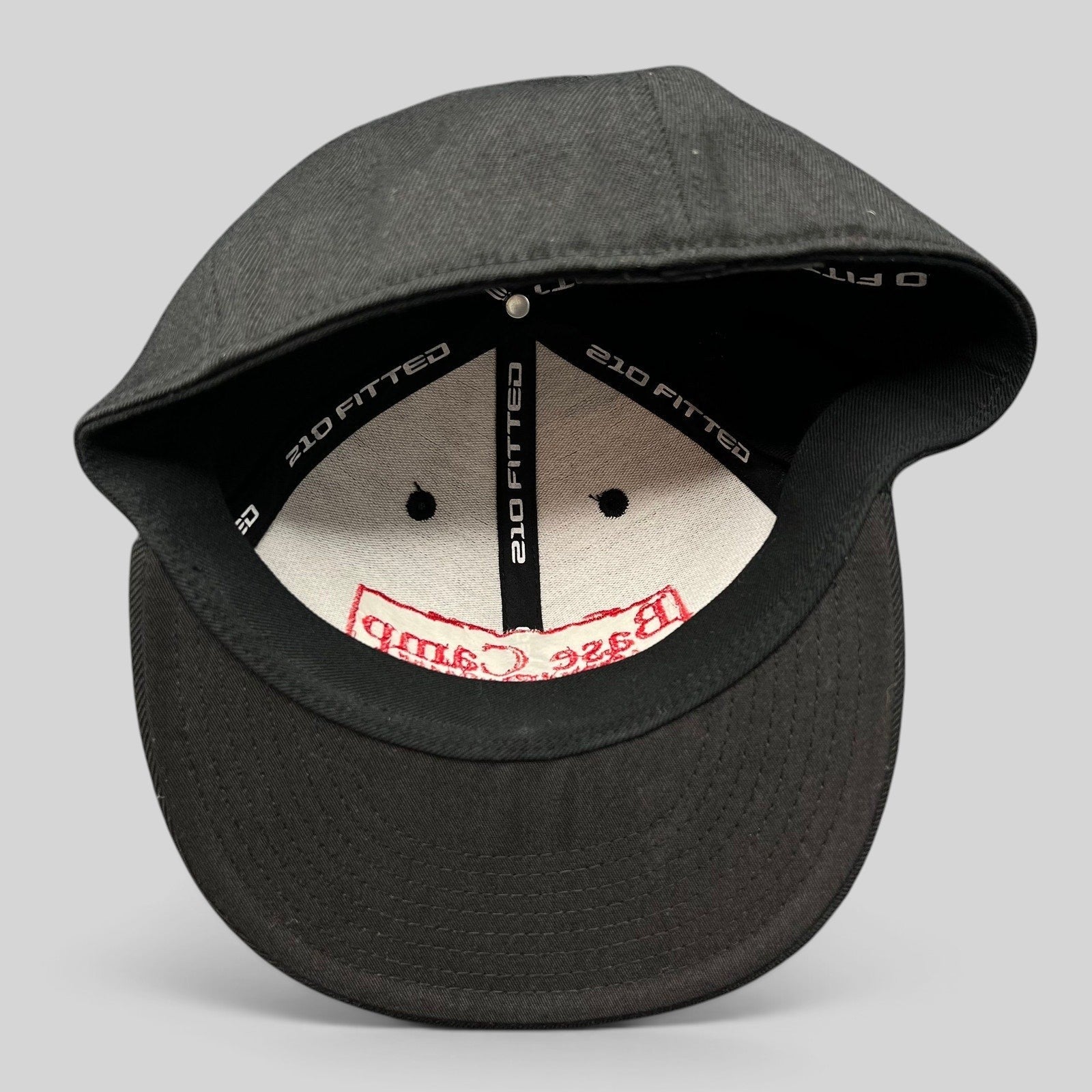 Raree Finds black Flexfit 210 fitted cap showing interior branding and structured crown construction
