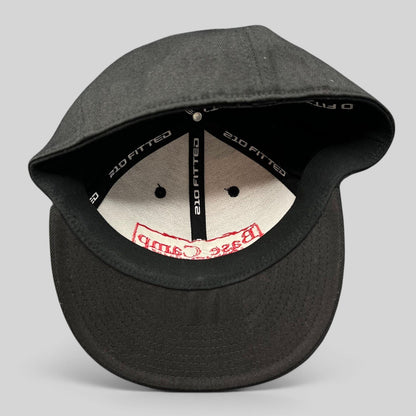 Raree Finds black Flexfit 210 fitted cap showing interior branding and structured crown construction