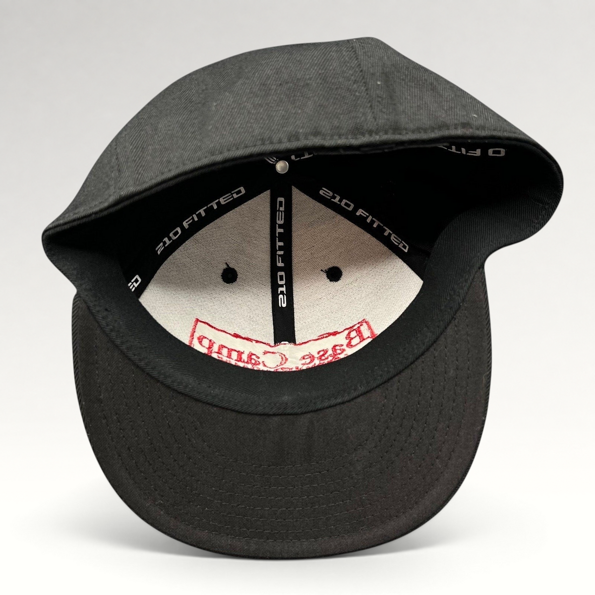 Raree Finds black Flexfit 210 fitted cap showing interior branding and structured crown construction