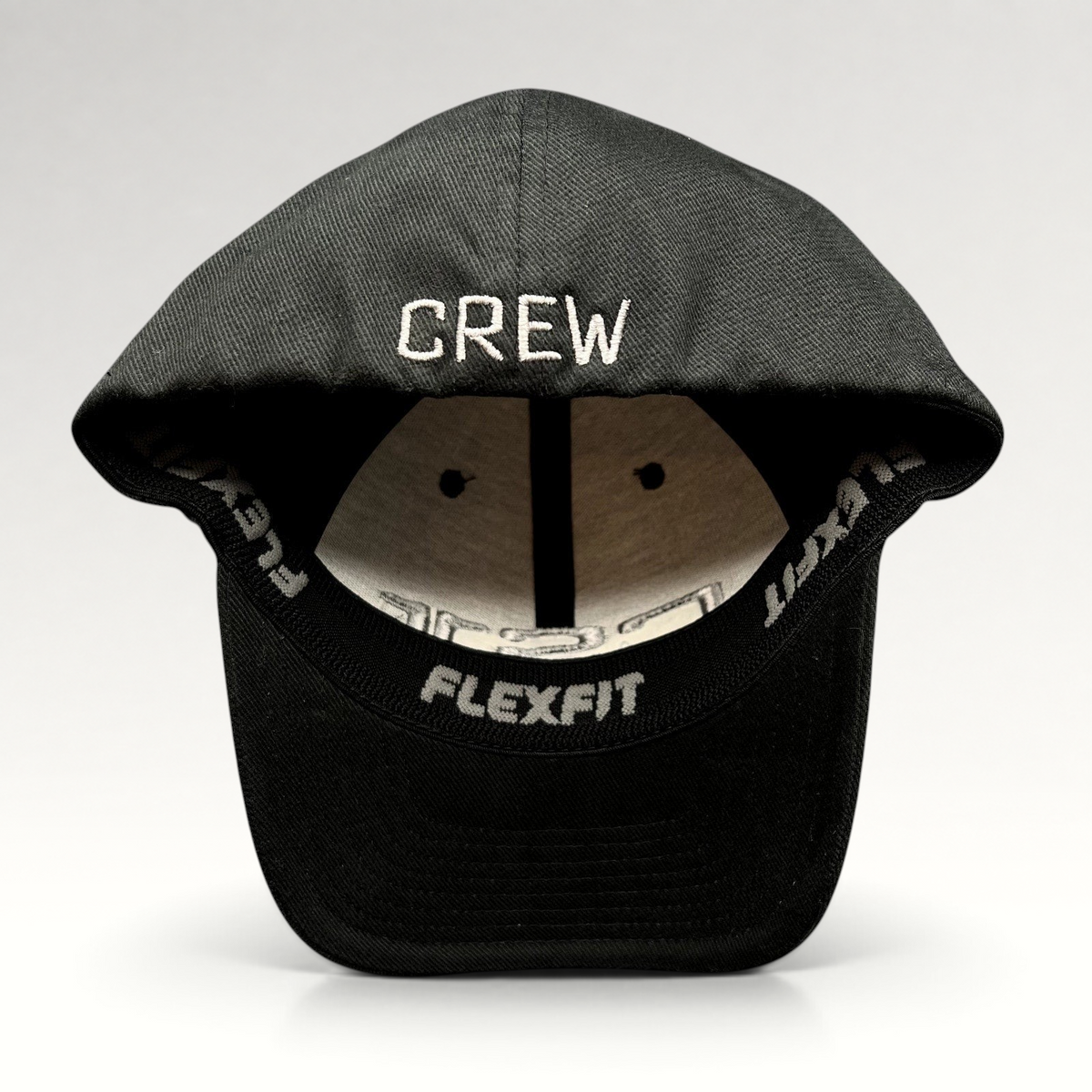 Raree Finds black Yupoong Flexfit cap with CREW embroidered in gray on the back interior brim