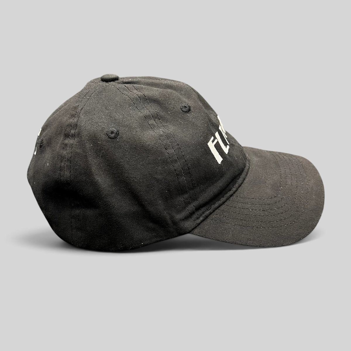 Raree Finds black unstructured six-panel strapback hat with white embroidered Flynn’s Irish pub logo and shamrock