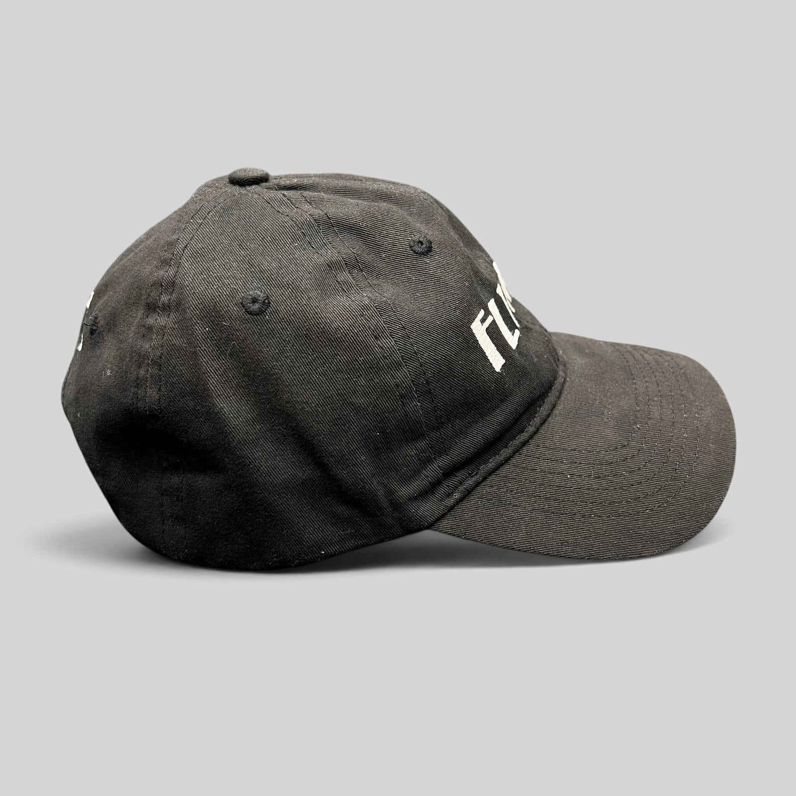 Raree Finds black unstructured six-panel strapback hat with white embroidered Flynn’s Irish pub logo and shamrock