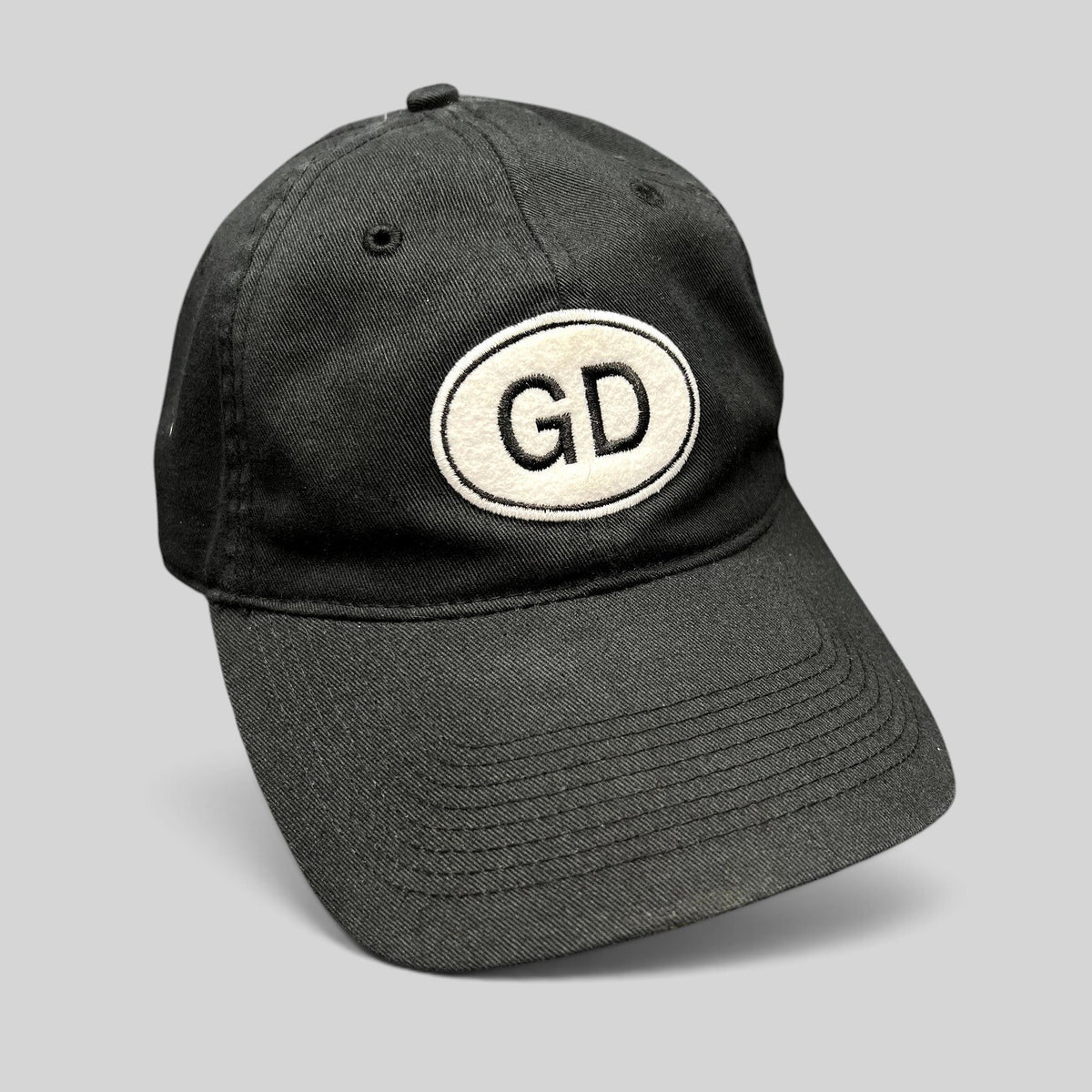 Raree Finds black cotton strapback hat featuring an oval GD logo patch on the front