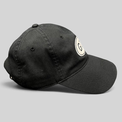 Raree Finds black cotton strapback hat featuring a white oval GD logo patch on the front side profile view