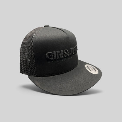 Raree Finds black Gin & Juice snapback hat with puff embroidery, mesh back, and flat brim on a dark background.