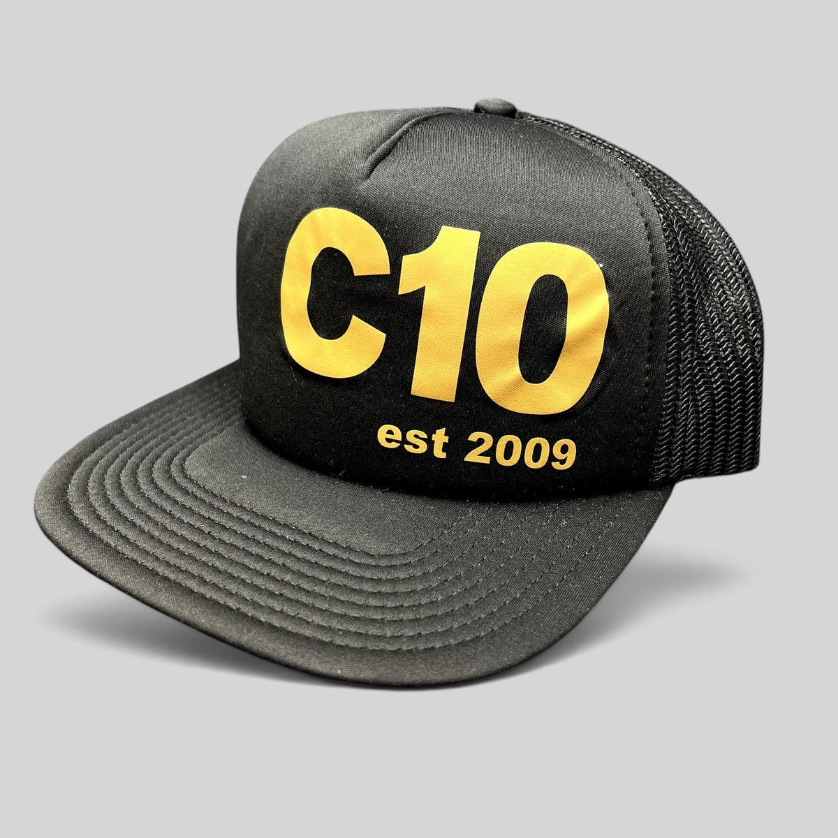 Raree Finds black and gold C10 trucker snapback hat with foam front, mesh back, and structured high crown profile.